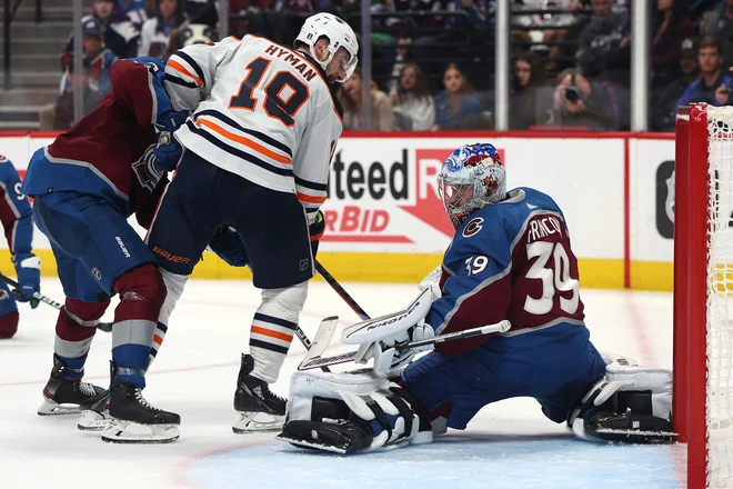 FOTO: Vratar ekipe Avalanche Pavel Francouz ustavlja Zacha Hymana na prvi tekmi v Denverju. FOTO: Harry How/AFP
