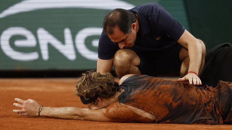 Fotografija: Alexander Zverev se je zgrudil v bolečinah. FOTO: Yves Herman/ Reuters
