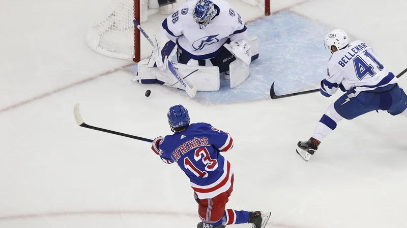 Andrej Vasiljevski poskuša ustaviti Alexisa Lafreniera v zadnji tretjini druge tekme v newyorškem Madison Square Gardnu. FOTO: Sarah Stier/AFP