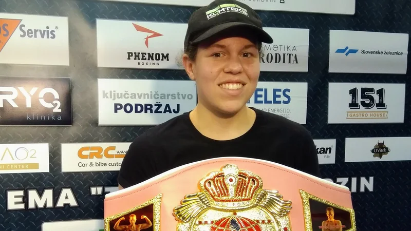 Fotografija: Ema Kozin je včeraj ponosno pokazala v soboto osvojeni posebni rožnati šampionski pas združenja WBF, na katerem sta dve njeni fotografiji. FOTO: Miha Šimnovec