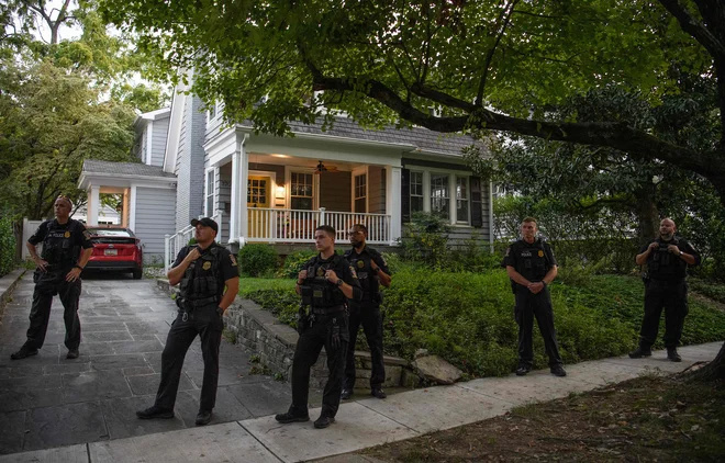 Policija pred sodnikovo hišo v marylandskem predmestju prestolnice Washington. FOTO:Nicholas Kamm/AFP

