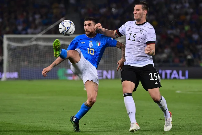 Niklas Süle (desno) ustavlja Italijana Lorenza Pellegrinija med obračunom lige narodov v Bologni. FOTO: Miguel Medina/AFP
