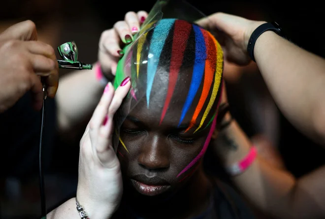 Manekenko ličijo v zakulisju pred začetkom modne revije »University of Westminster MA Menswear«, ki se je odvila v okviru londonskega tedna mode. Foto: Henry Nicholls/Reuters