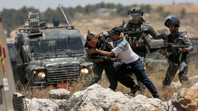 Fotografija: Palestinec se spopada z izraelskimi silami med protestom proti izraelskemu naseljevanju v bližini Hebrona na Zahodnem bregu, ki ga zaseda Izrael. Foto: Mussa Issa Qawasma/Reuters