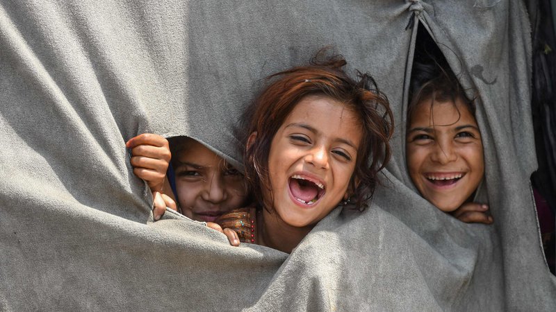 Fotografija: Otroci afganistanskih beguncev, ki živijo v Pakistanu, se zabavajo v začasnem šotoru na obrobju Lahoreja, na predvečer svetovnega dneva beguncev. Foto: Arif Ali/Afp
