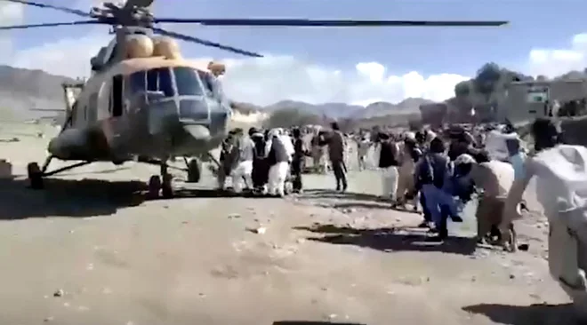 Ljudje nosijo ranjene proti helikopterju, potem ko je Afganistan sinočli stresel močan potres. FOTO: Bakhtar News Agency/Reuters
