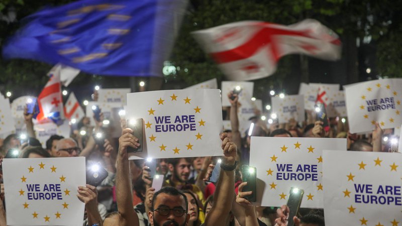 Fotografija: »Sem Gruzijec, torej Evropejec« in »Domov v Evropo« je bilo mogoče prebrati na transparentih ogorčene množice, ki je ob zvokih evropske himne protestirala proti vladi. FOTO: Irakli Gedenidze/Reuters
