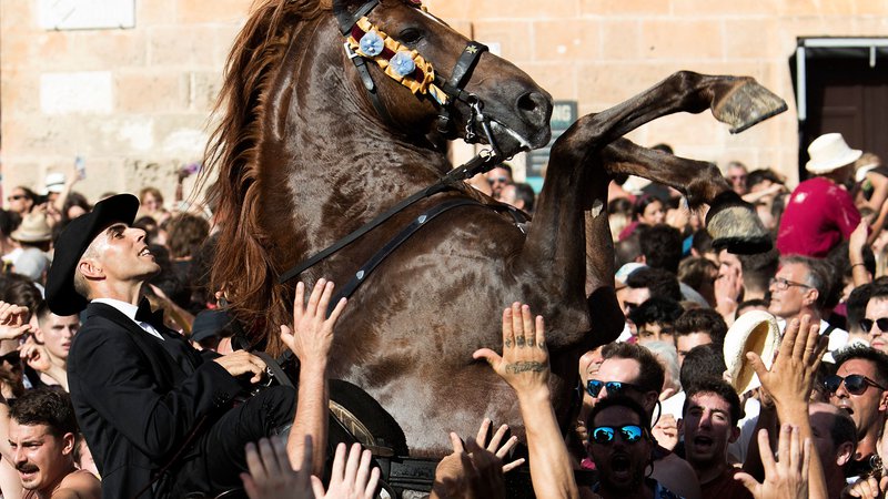 Fotografija: V mestu Ciutadella na španskem otoku Minorca je potekalo množično srečanje konj in ljudi, ki se vrtijo v ritmu glasbe v okviru tradicionalnega festivala Sveti Janez, na predvečer verskega praznika. Foto: Jaime Reina/Afp
