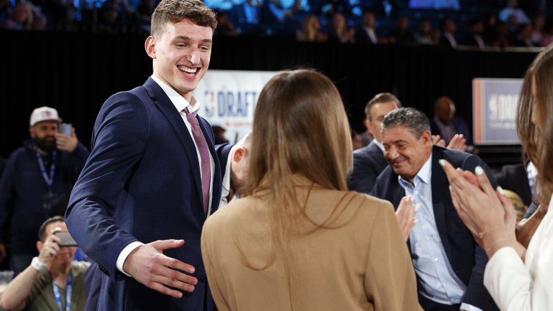 Fotografija: Nikola Jović z družino v dvorani Barclays Center v New Yorku, kjer je bil prejšnji četrtek na sporedu nabor lige NBA. FOTO: Sarah Stier/AFP
