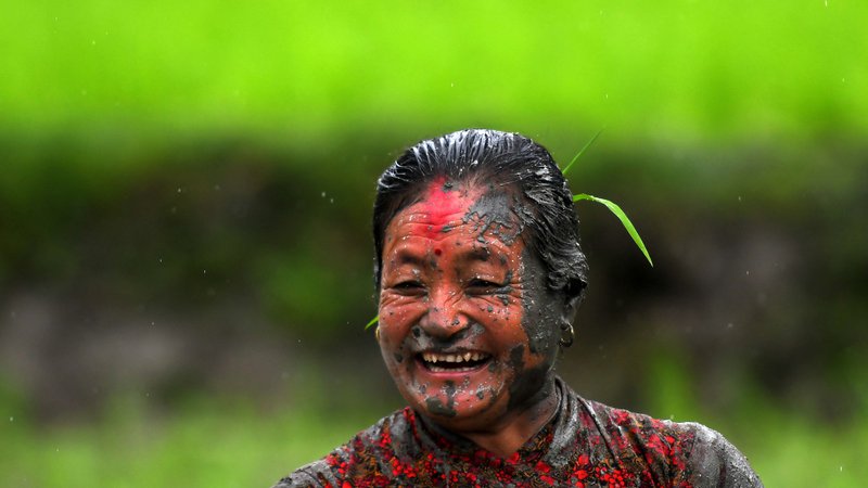 Fotografija: Blatna kmetica se smehlja na riževem polju med nacionalnim dnevom riža, ki zaznamuje začetek letne sezone sajenja riža, v vasi Tokha na obrobju Katmanduja. Foto: Prakash Mathema/Afp
