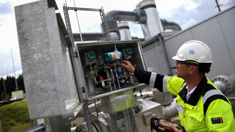 Fotografija: Delavec Uniperja preverja stanje v skladiščih plina. Foto Andreas Gebert/Reuters
