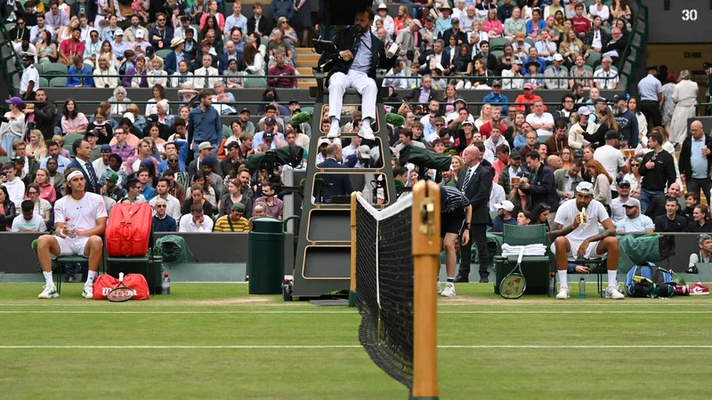 Fotografija: Nick Kyrgios (desno) si je privoščil banano med premorom dvoboja s Stefanosom Tsitsipasom. FOOT: Glyn Kirk/AFP
