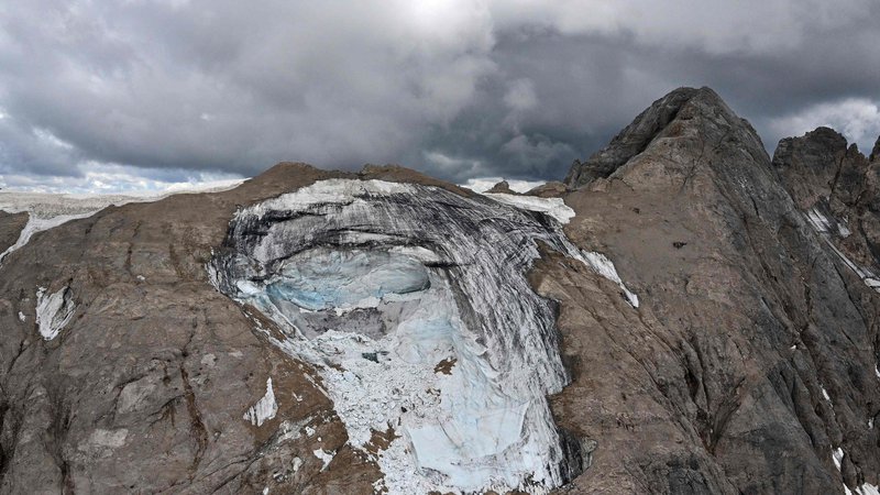 Fotografija: Na grozljive podnebne razmere je javnost najglasneje opomnila nesreča na Marmoladi, kjer se je z ledenika utrgal serak in pod seboj pokopal doslej neznano število ljudi. Foto Tiziana Fabi/AFP
