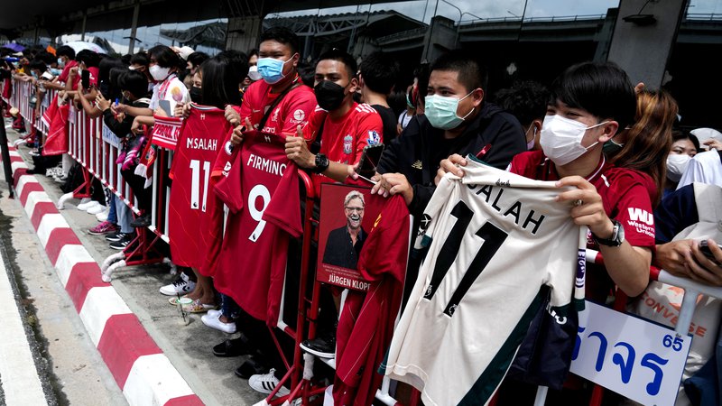 Fotografija: Nogometaše Liverpoola so na letališču v Bangkoku takole pričakali njihovi tajski navijači. Rdeči se bodo v torek merili z Manchester Unitedom. FOTO: Athit Perawongmetha/Reuters
