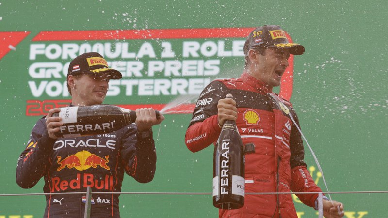 Fotografija: Max Verstappen je po dirki pošteno poškropil Charlesa Leclerca s šampanjcem. FOTO: Leonhard Foeger/Reuters
