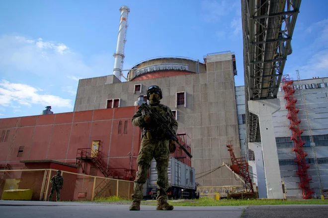 Ruski vojak pred nuklearko v Zaporožju po zasedbi območja. FOTO: Andrey Borodulin/AFP