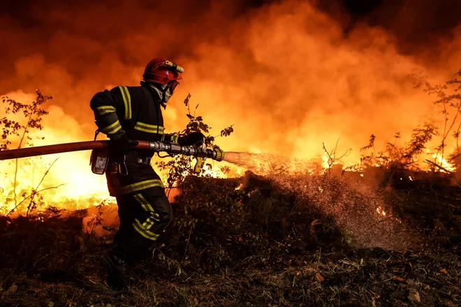 Gasilec se bori z ognjenimi zublji na jugozahodu Francije. FOTO: Thibaud Moritz/AFP
