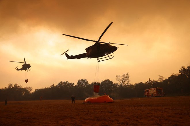Gašenje iz zraka je oviral gost dim, ogenj pa je uničil tudi bazen, iz katerega so helikopterji zajemali vodo. FOTO: Črt Piksi/Delo
