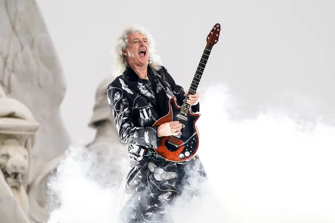 Brian May je junija ob platinastem jubileju Elizabete II. nastopil pred londonsko Buckinghamsko palačo. FOTO: Pool Reuters