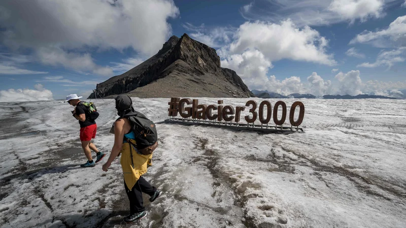 Fotografija: Turisti se sprehajajo na ledeniku Tsanfleuron nad Les Diableretsom v Švici. Po več vročinskih valovih, za katere znanstveniki krivijo podnebne spremembe, se v Švici vse hitreje talijo alpski ledeniki. Foto: Fabrice Coffrini/Afp