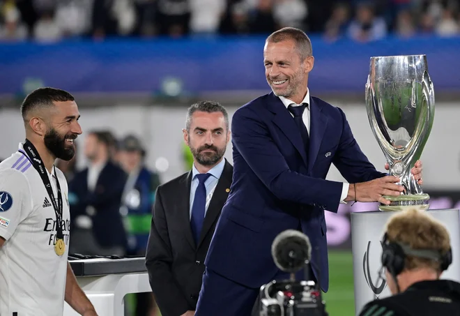 Karim Benzema je takole prejel pokal iz rok Aleksandra Čeferina. FOTO: Javier Soriano/AFP
