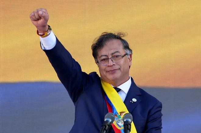 Novi kolumbijski predsednik Gustavo Petro je med prisego na Trgu Bolivar Bogoti v zrak dvignil stisnjeno pest. FOTO: Luisa Gonzalez/Reuters

