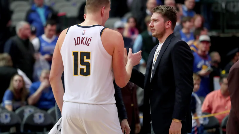 Fotografija: Nikola Jokić v pogovoru z Luko Dončićem po tekmi lige NBA v Dallasu. FOTO: Tom Pennington/AFP