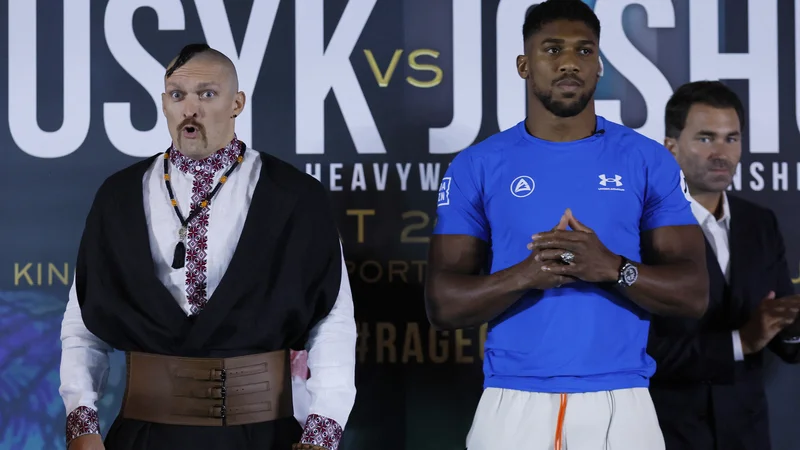 Fotografija: Oleksandr Usik (levo) je na soočenje z Anthonyjem Joshuo prikorakal v ukrajinski narodni opravi. FOTO: Andrew Couldridge/Reuters
