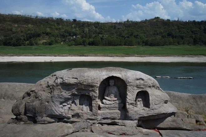 Eine Insel mit drei buddhistischen Statuen ist aufgrund von Hitzewellen und Dürre aus den ausgetrockneten Teilen des Jangtse in der Nähe von Chongqing im Südwesten Chinas entstanden.  FOTO: Thomas Peter/Reuters