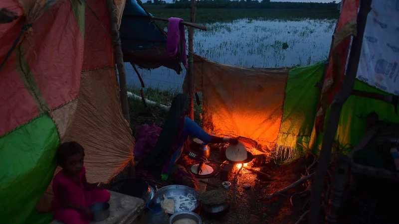 Fotografija: V začasnem taboru ženska kuha hrano za svojo družino, ki so jo po obilnem monsunskem deževju prizadele poplave v provinci Sindh na jugu Pakistana. Podatki nacionalne agencije za naravne nesreče so 25. avgusta pokazali, da je od junija v poplavah umrlo 903 ljudi, več kot 180.000 pa jih je bilo prisiljenih zapustiti svoje podeželske domove. Foto: Asif Hassan/Afp