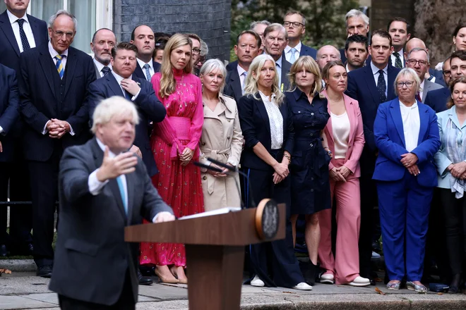 »Zdaj bom pljusknil v neki oddaljeni kotiček Tihega oceana,« je dejal Johnson pred vrati Downing Streeta 10, obkrožen s sodelavci. FOTO: Kevin Coombs/Reuters
