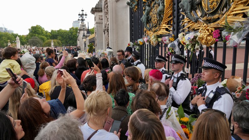 Fotografija: Takoj po smrti kraljice so se pred Buckinghamsko palačo v Londonu začeli zbirati ljudje, včeraj pa so pozdravili novega kralja Karla III. Foto Maja Smiejkowska/Reuters
