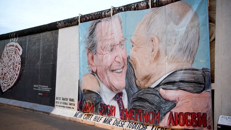 Fotografija: Nemški kancler Gerhard Schröder je simbol vzpostavljanja nevarne odvisnosti Nemčije od Rusije pri preskrbi s plinom. »Moj Bog, pomagaj mi preživeti to smrtno ljubezen,« je zapisano pod sliko objemanja Schröderja in Putina na ostanku berlinskega zidu, poimenovanem East Side Gallery. FOTO: Reuters
