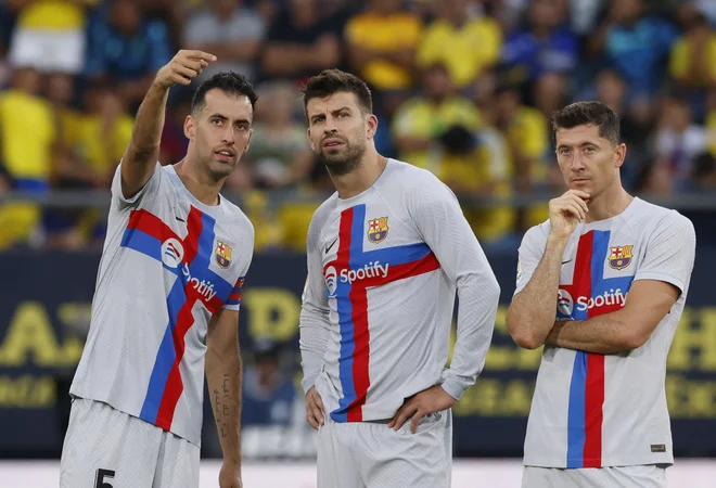 Tudi Sergio Busquets, Gerard Pique in Robert Lewandowski so opazovali dogajanje okrog nesrečnega navijača. FOTO: Marcelo Del Pozo/Reuters