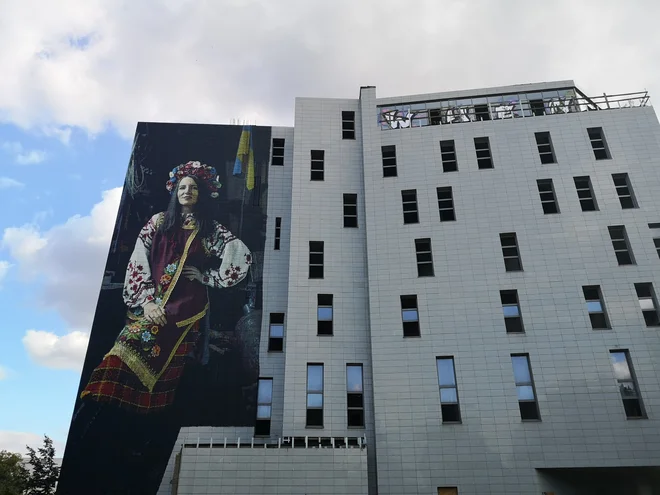 Najnovejši mural na nesojeni Moskovski hiši v Vilni s podobo prostovoljke v ukrajinski narodni noši iz begunskega centra v Zaporožju FOTO: Marko Gams
