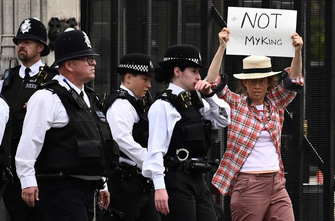 Po smrti kraljice Elizabete II., ki je umrla 8. septembra, protestnica protestira proti novemu kralju pred Westminstrsko palačo v središču Londona. Foto: Marco Bertorello/Afp