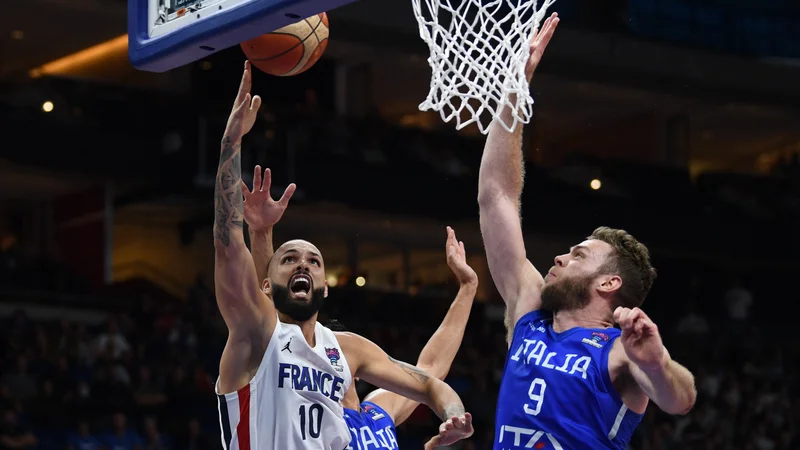 Fotografija: Evan Fournier poskuša zadeti ob Nicolu Melliju. FOTO: Annegret Hilse/Reuters