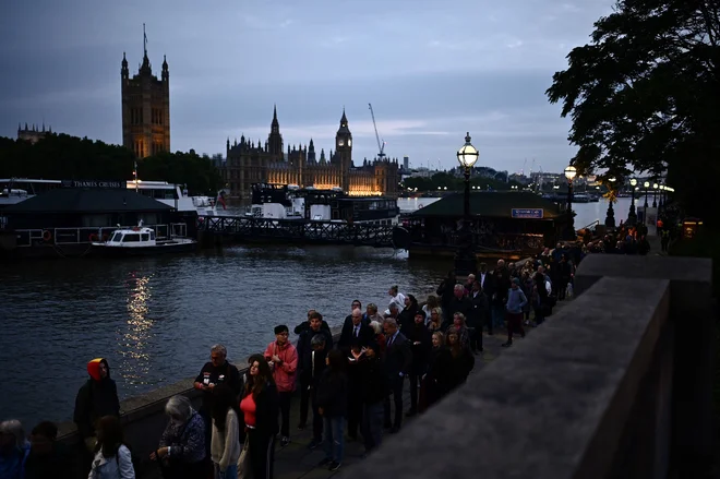 Nepregledna množica čaka tudi ponoči. FOTO Marco Bertorello/AFP
