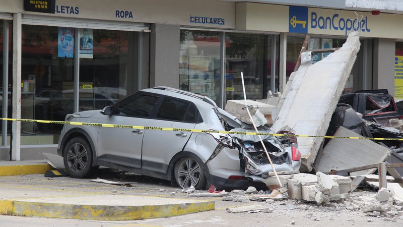Fotografija: VozilI, poškodovanI zaradi zrušitve fasade veleblagovnice med potresom v Mehiki. FOTO: Reuters

