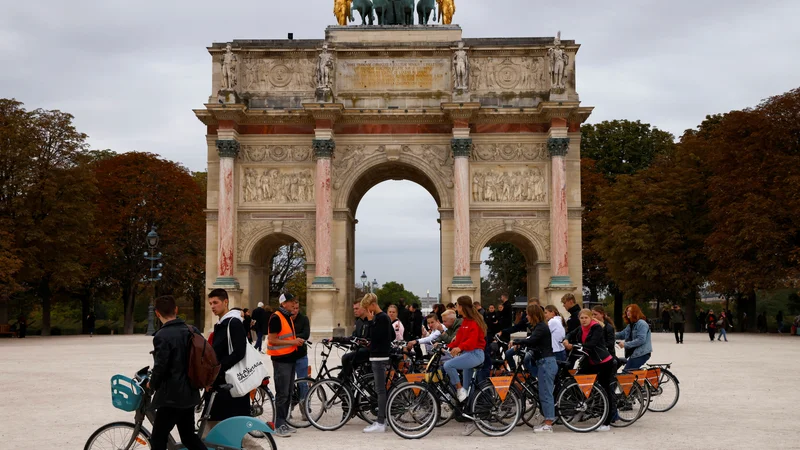Fotografija: Turisti na kolesu pred Slavolokom zmage. FOTO: Stringer/Reuters