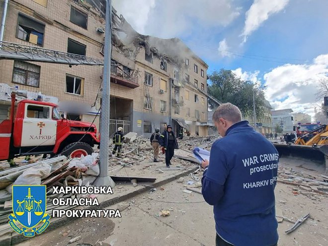 Tožilec za vojne zločine pregleduje stanovanjsko stavbo, ki je bila poškodovana zaradi ruskega vojaškega napada v Harkovu. FOTO: Kharkiv Region Prosecutor's Offi/Reuters
