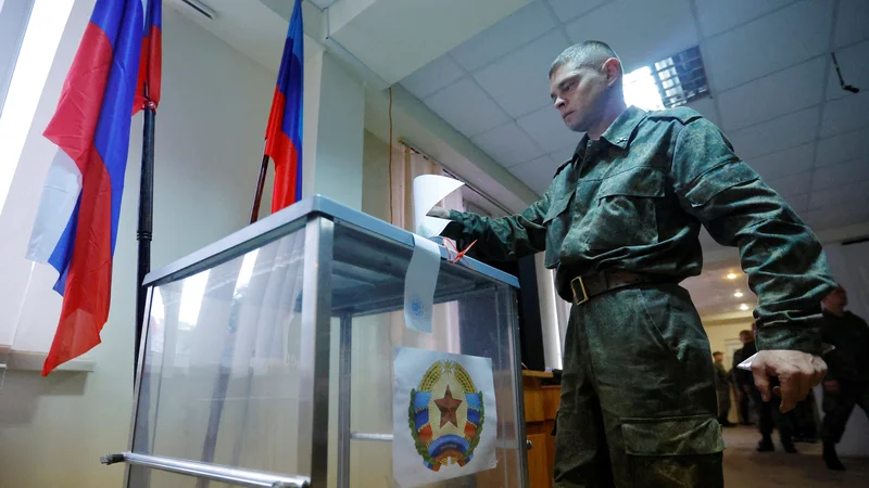 Fotografija: Pripadnik proruske vojske samooklicane Luganske ljudske republike glasuje na referendumu o priključitvi Ruski federaciji. FOTO: Alexander Ermochenko/Reuters
