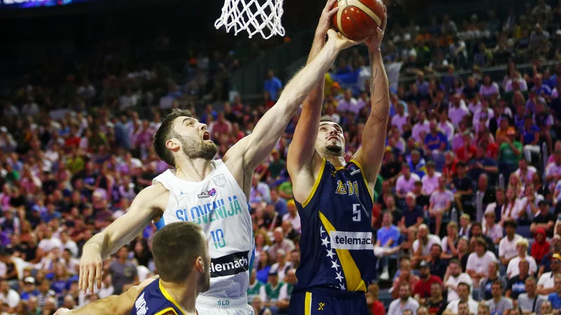 Fotografija: Mike Tobey (levo) in Edin Atić med dvobojem skupine B letošnjega evropskega prvenstva v Kölnu med Slovenijo ter Bosno in Hercegovino. FOTO: Thilo Schmuelgen/Reuters