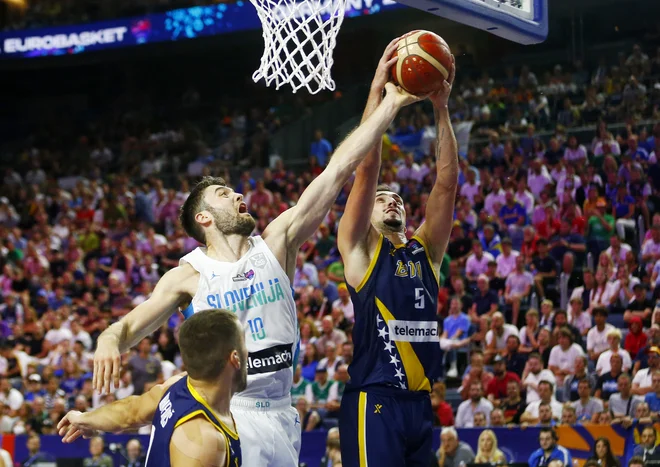 Mike Tobey (levo) in Edin Atić med dvobojem skupine B letošnjega evropskega prvenstva v Kölnu med Slovenijo ter Bosno in Hercegovino. FOTO: Thilo Schmuelgen/Reuters
