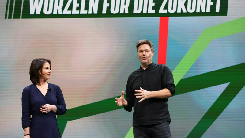 Fotografija: Ministrica za zunanje zadeve Annalena Baerbock in minister za gospodarstvo in podnebne politike Robert Habeck pod napisom »Korenine za prihodnost« FOTO: Christian Mang/REUTERS