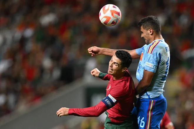 Cristiano Ronaldo v skoku ob Rodriju. FOTO: Patricia De Melo Moreira/AFP

