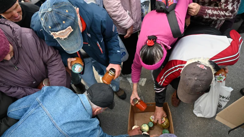 Fotografija: Humanitarna pomoč v obliki hrane, ki jo je priskrbela krščanska verska organizacija, se razdeljuje lokalnim prebivalcem v ukrajinskem mestu Izjum. FOTO: Sergej Bobok/AFP