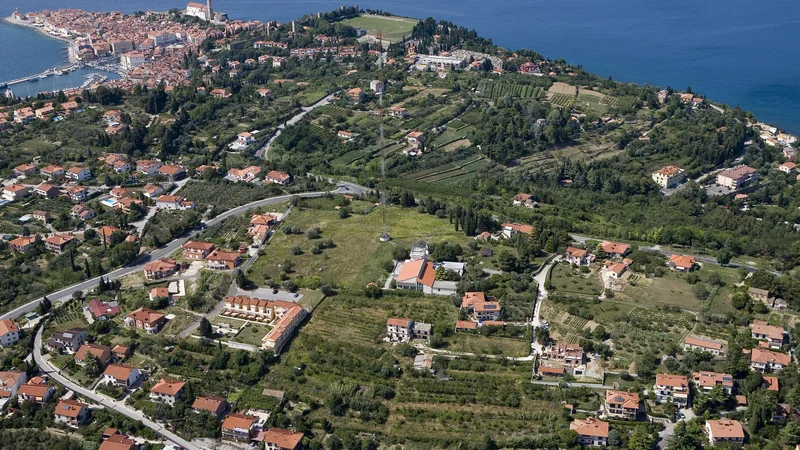 Fotografija: Parcela, na kateri bodo zrasle Sončne vile, je tik ob zemljišču RTV-oddajnika Beli Križ, nedaleč od antene (sredi fotografije). Foto Jaka Jeraša
