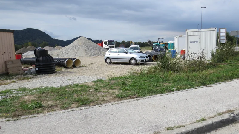 Fotografija: Ob robu poslovne cone bo Trgograd zamenjal dotrajani vodovod, razširil cesto in pločnik. FOTO: Bojan Rajšek/Delo
