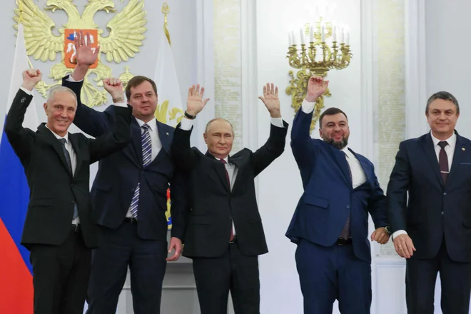 Ruski predsednik Vladimir Putin (v sredini) je s proruskimi voditelji štirih ukrajinskih regij, kjer so pred dnevi potekali sporni referendumi, podpisal sporazum o njihovi priključitvi k Ruski federaciji. FOTO:&nbsp;Mihail Mecel/AFP
